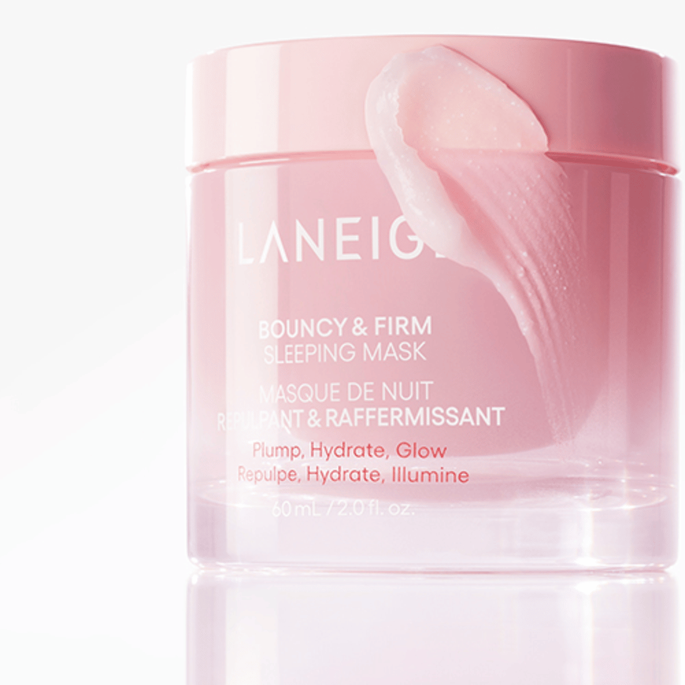 Närbild på Laneige Bouncy & Firm Sleeping Mask i en rosa burk, med en del av masken som appliceras på kanten av locket. Produkten är avsedd för att ge plump, återfuktning och glöd. Burken rymmer 60 ml och har texten "Plump, Hydrate, Glow."