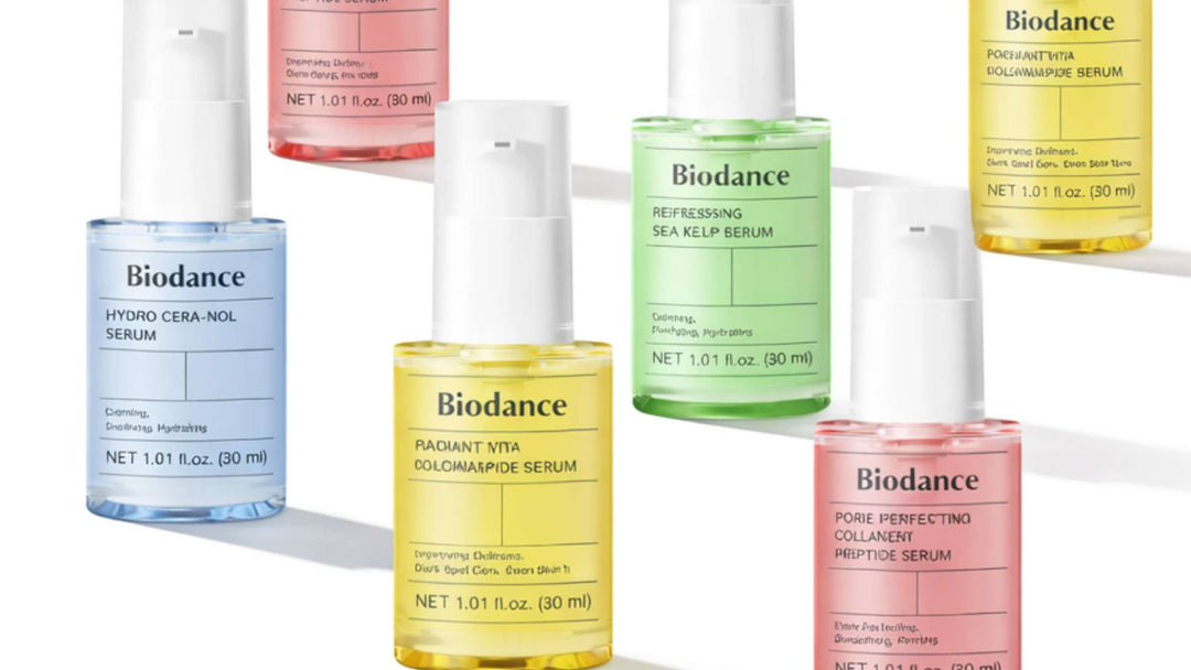 En genomskinlig flaska med COSRX Advanced Snail 96 Mucin Power Essence vält, med essence droppande ner i en glaskärl på en neutral bakgrund.