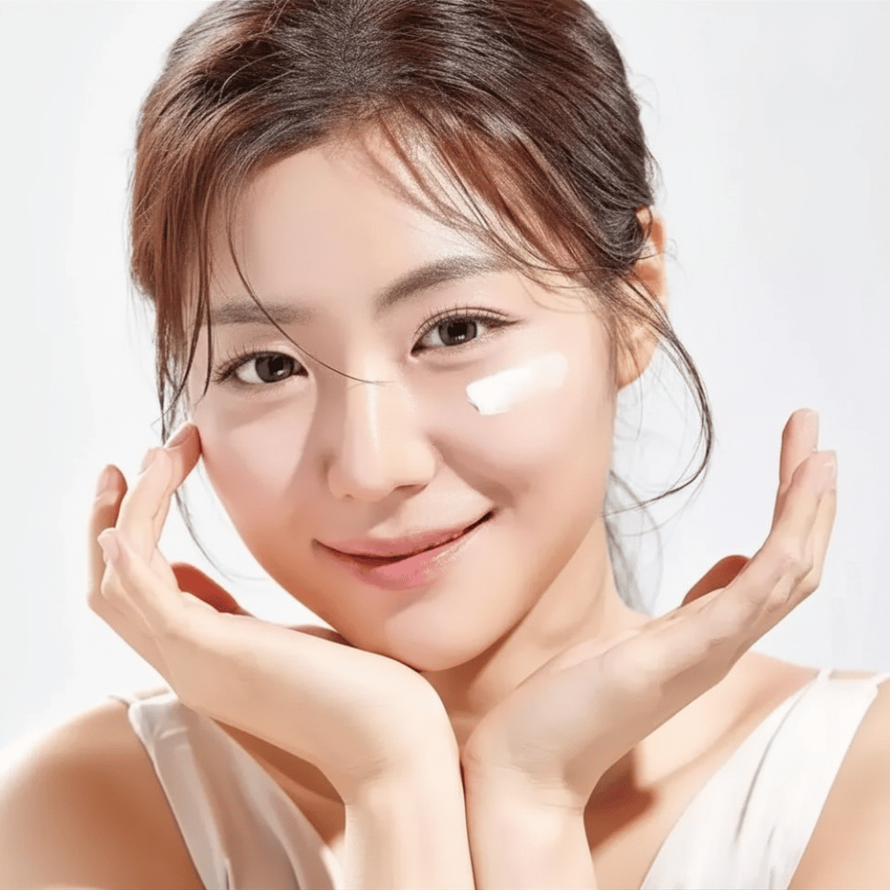 Mulher aplica Round Lab 1025 Dokdo Eye Cream sob os olhos para hidratação, luminosidade e um tom de pele mais uniforme