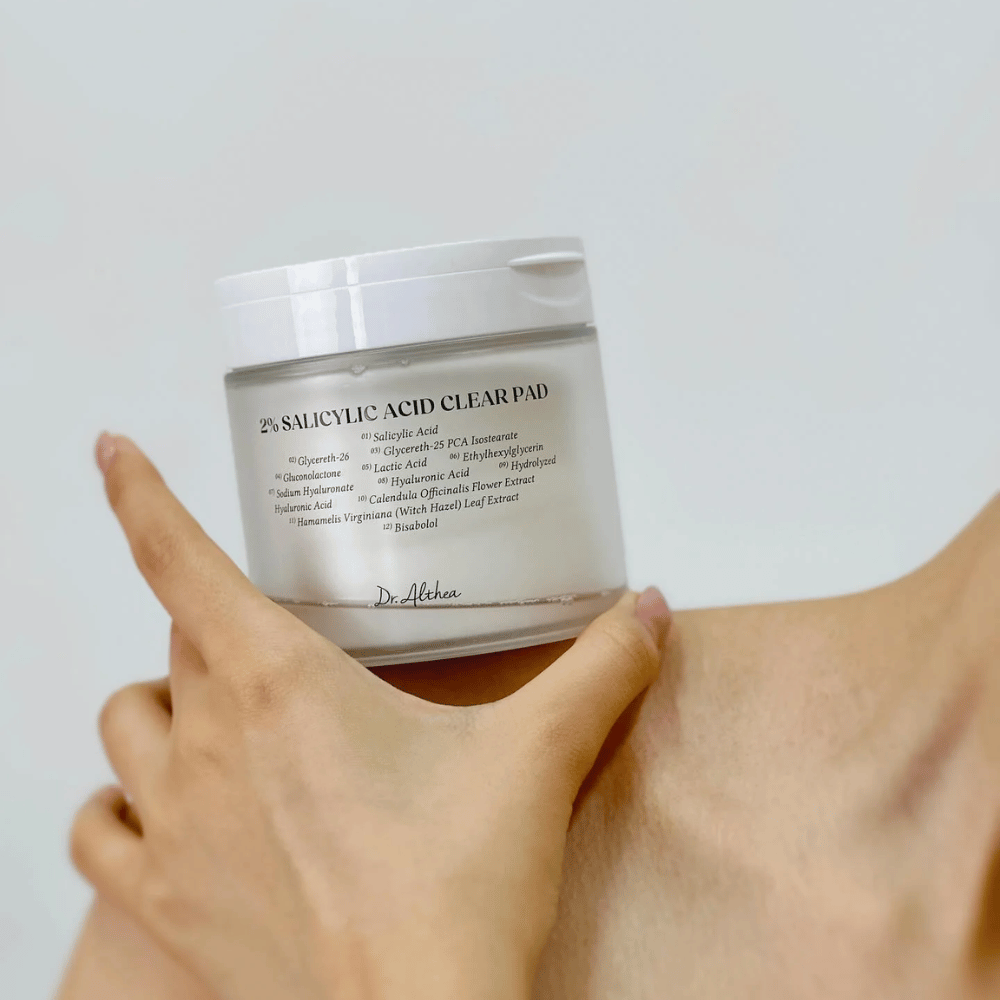Dr. Althea 2% Salicylic Acid Clear Pad segurado na mão. Discos de tónico com 2% de ácido salicílico que esfoliam suavemente, acalmam a pele e melhoram a textura da pele.