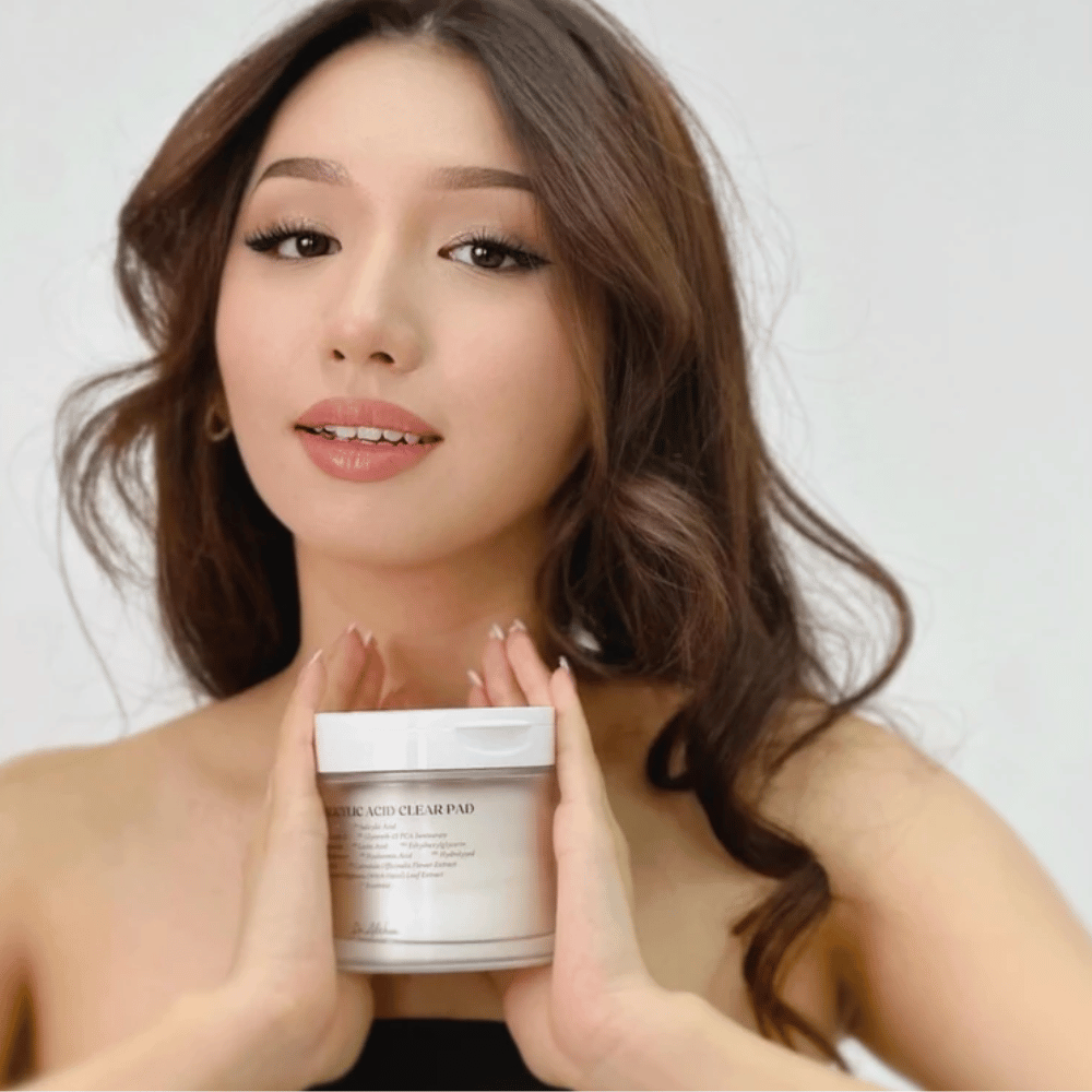Modelo segura Dr. Althea 2% Salicylic Acid Clear Pad em frente ao rosto. Discos de tónico esfoliantes com ácido salicílico que limpam os poros, equilibram o sebo e proporcionam uma pele mais clara.