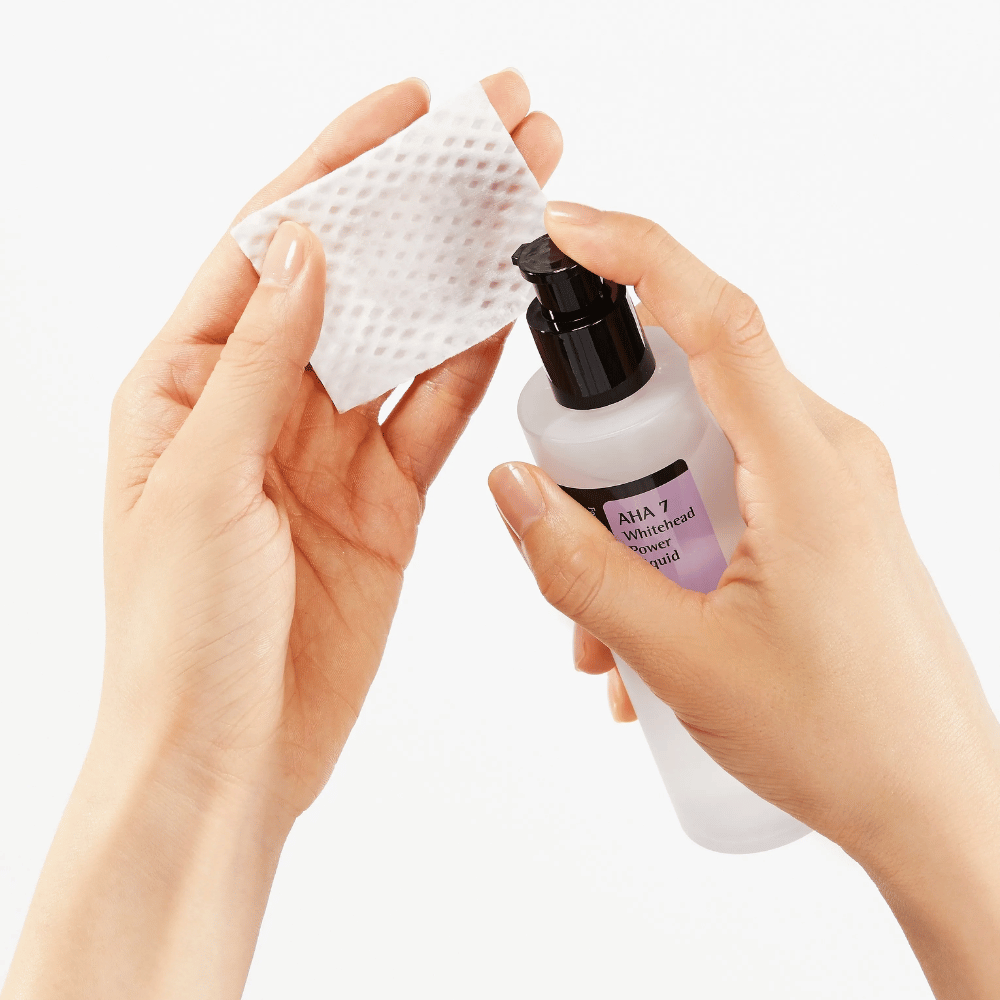 Aplicação de COSRX AHA 7 Whitehead Power Liquid em disco de algodão, tônico esfoliante com AHA para remover células mortas da pele e melhorar a textura da pele.