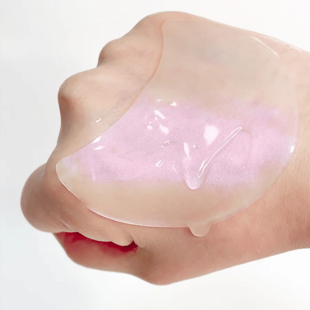 Patch de hidrogel rosa com retinol exibido em uma mão, fórmula hidratante e iluminadora.