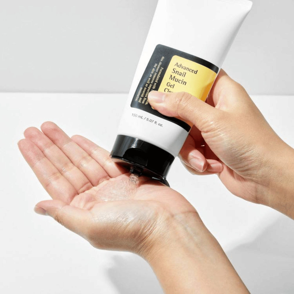 Mão aplica COSRX Advanced Snail Mucin Gel Cleanser – limpeza em gel suave com mucina de caracol que limpa profundamente e mantém o equilíbrio de umidade da pele.