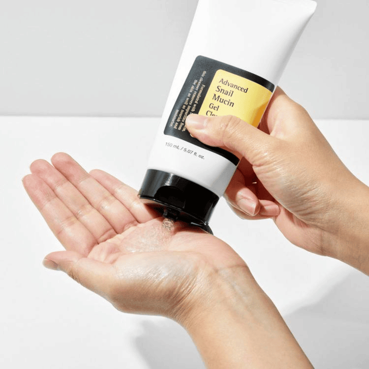 Mão aplica COSRX Advanced Snail Mucin Gel Cleanser – limpeza em gel suave com mucina de caracol que limpa profundamente e mantém o equilíbrio de umidade da pele.
