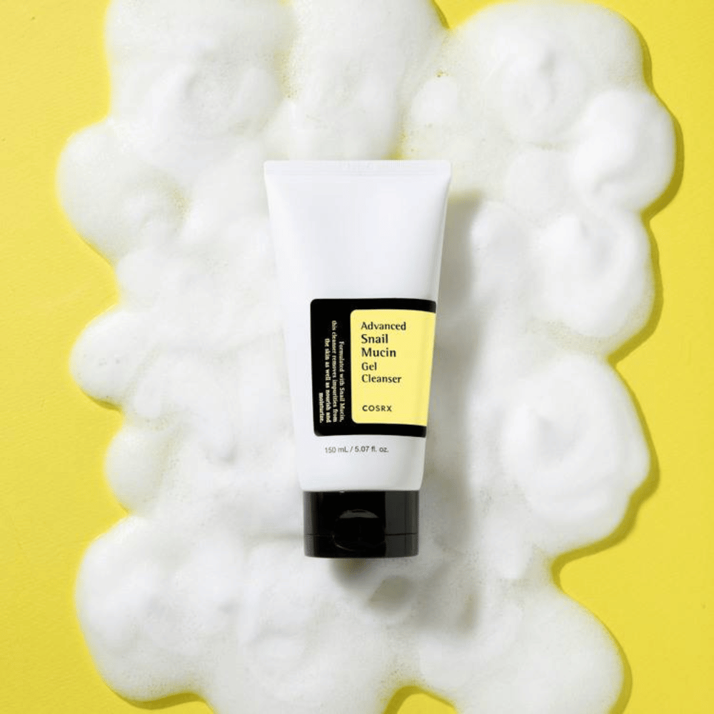 COSRX Advanced Snail Mucin Gel Cleanser 150 ml rodeado de espuma abundante em fundo amarelo – coreano suave limpeza facial com snail mucin para hidratação e brilho.