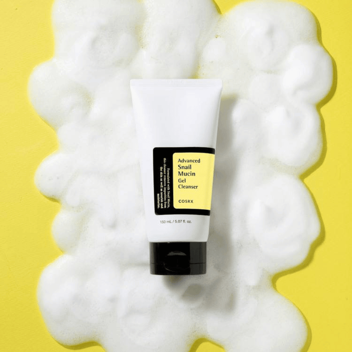 COSRX Advanced Snail Mucin Gel Cleanser 150 ml rodeado de espuma abundante em fundo amarelo – coreano suave limpeza facial com snail mucin para hidratação e brilho.