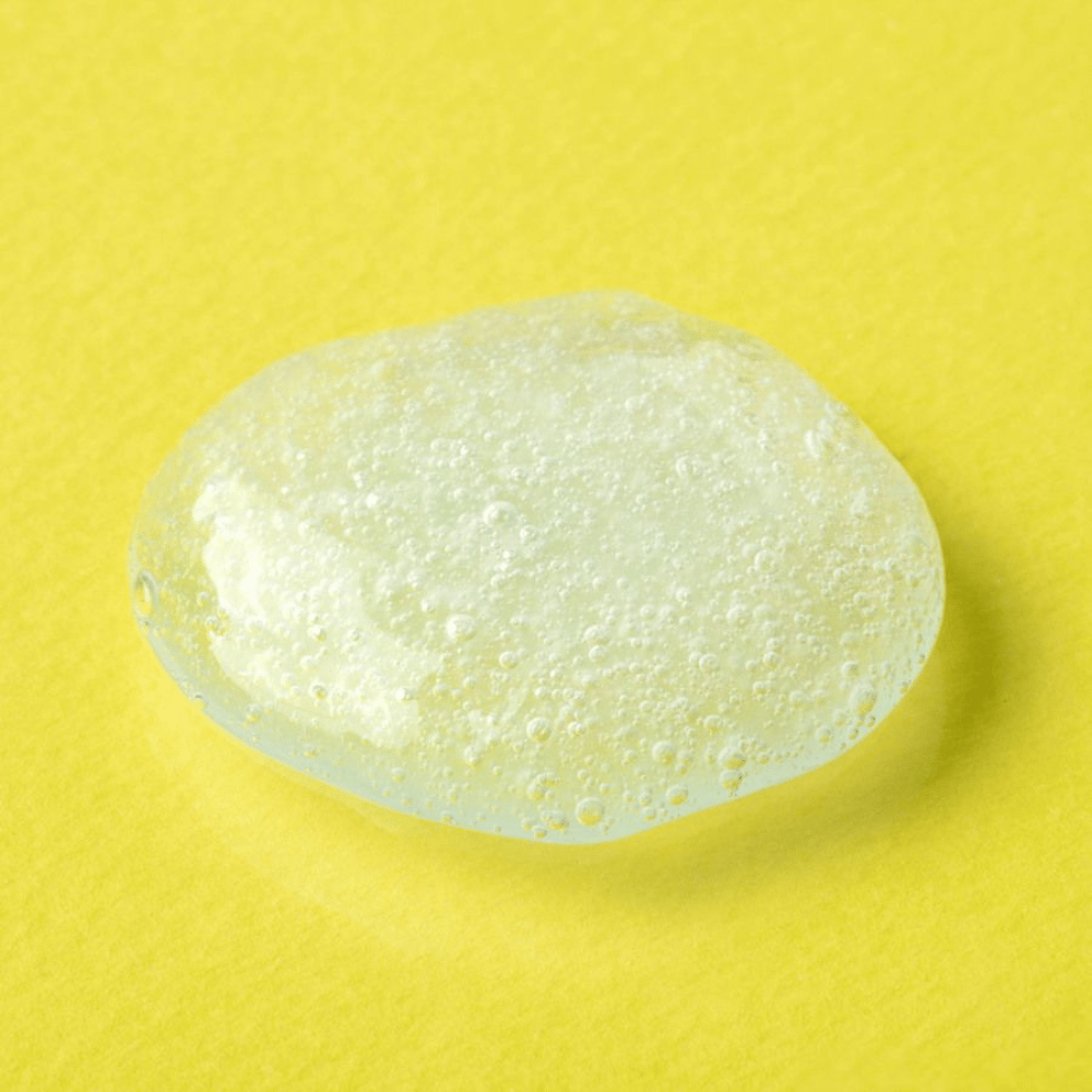 Textura de gel transparente de COSRX Advanced Snail Mucin Gel Cleanser em fundo amarelo – hidratante limpeza facial com secreção de caracol para pele macia e equilibrada.