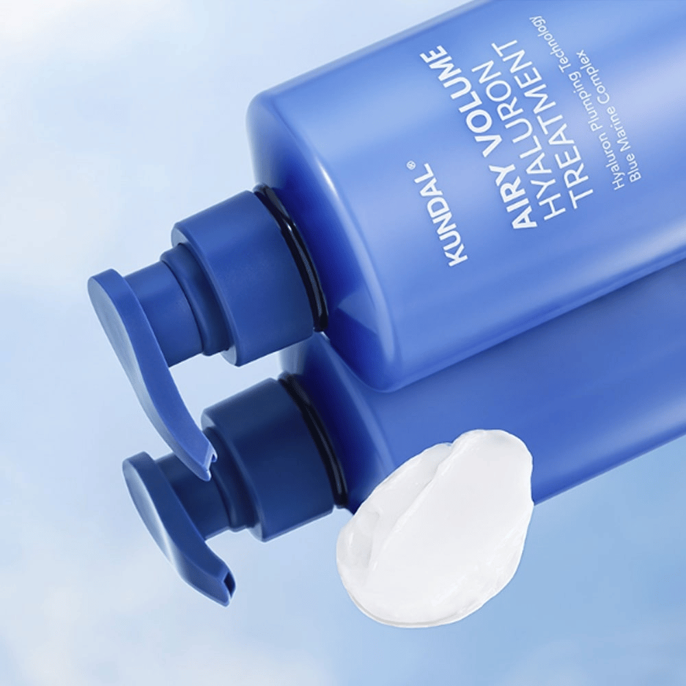 KUNDAL Airy Volume Hyaluron Treatment em frasco de bomba azul deitado, com produto creme branco visível ao lado.