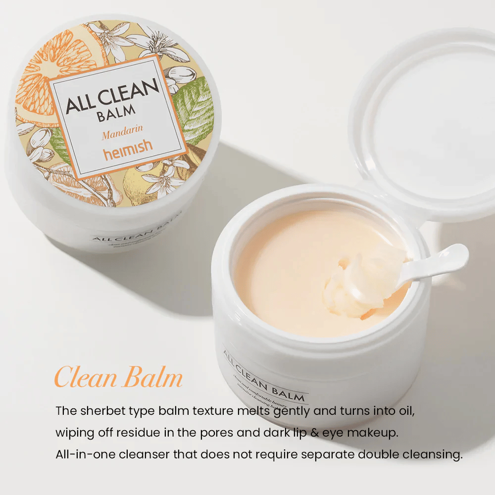 Frasco aberto de Heimish All Clean Balm Mandarin com uma colher mexendo o bálsamo de limpeza cremoso, com um rótulo colorido e o texto 'Clean Balm' em primeiro plano.