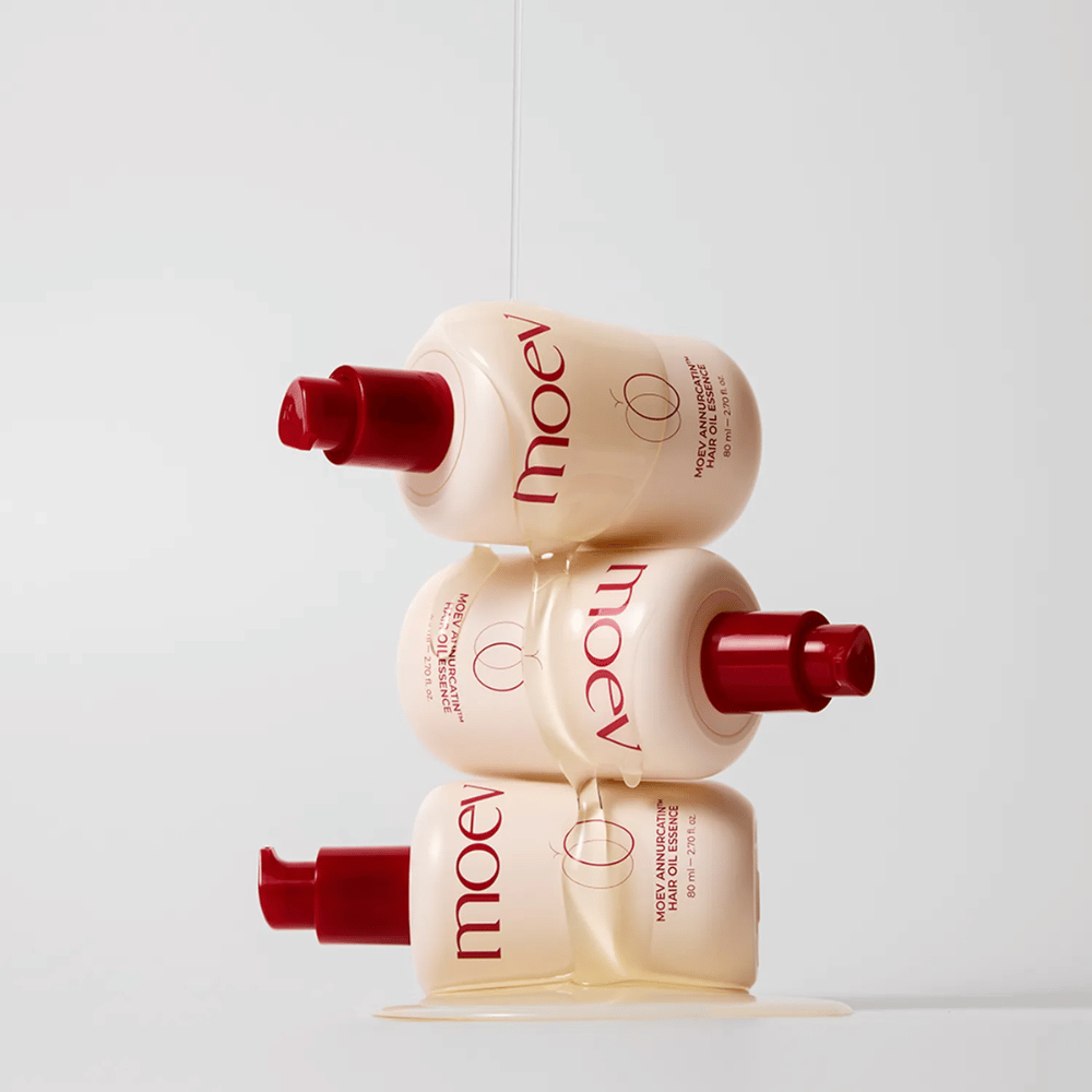 Três frascos MOEV Annurcatin Hair Oil Essence empilhados – óleo capilar nutritivo com maçã Annurca e biotina que fortalece, protege e dá brilho e elasticidade ao cabelo.