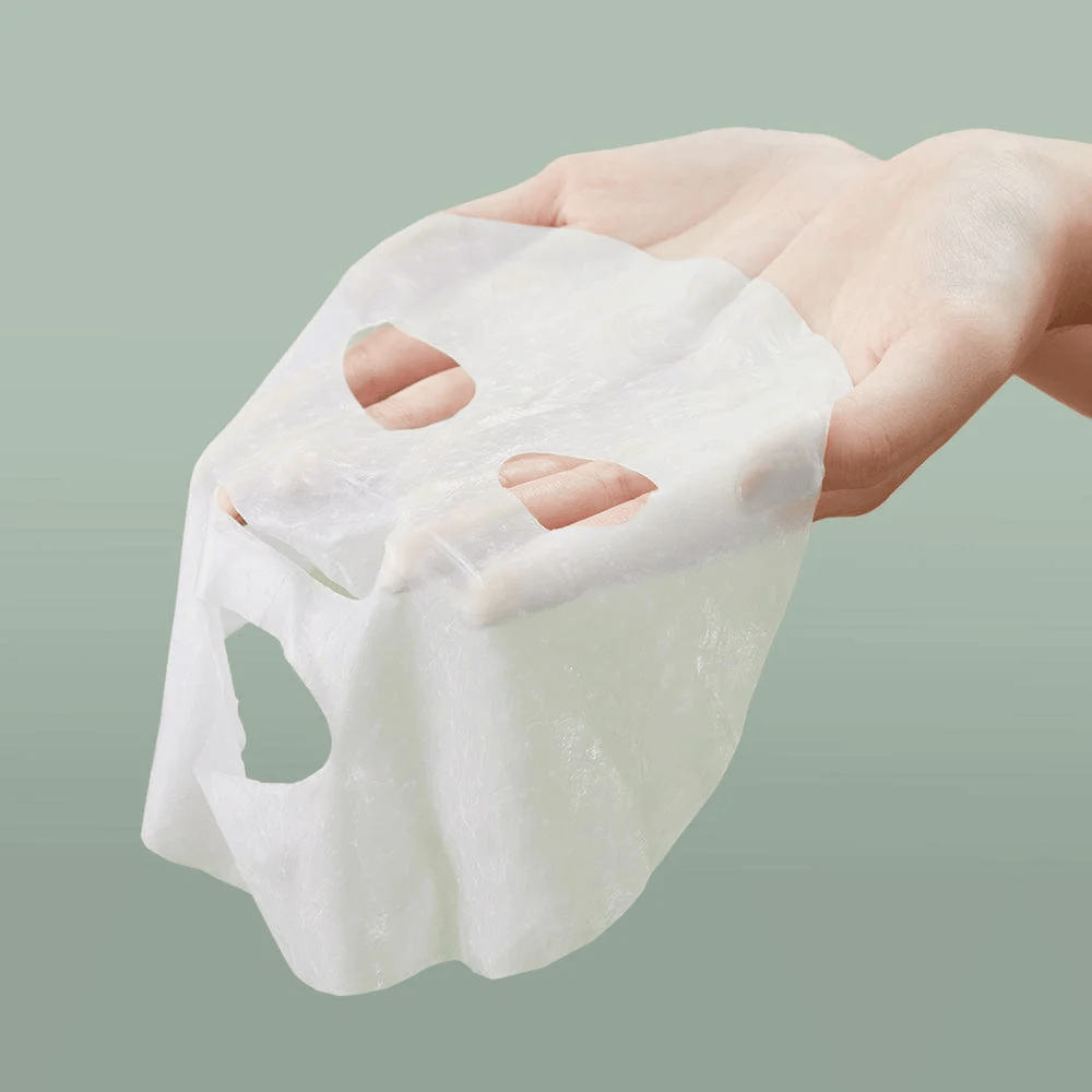 A mão de uma pessoa segurando Anua Heartleaf 77% Soothing Sheet Mask.