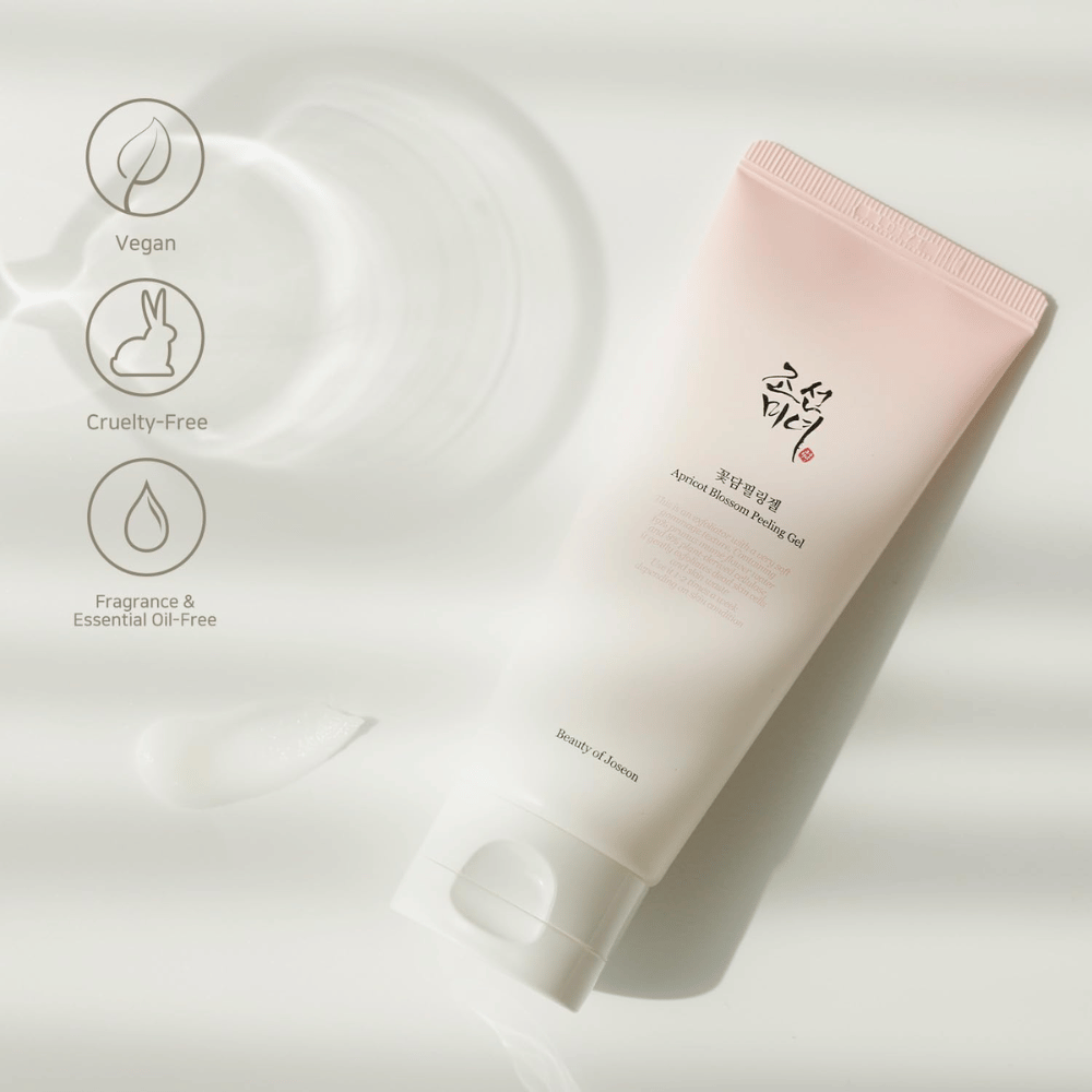 Um tubo com Apricot Blossom Peeling Gel está sobre uma superfície refletora com ícones que indicam que o produto é vegano, amigável aos animais e livre de fragrâncias e óleos essenciais.