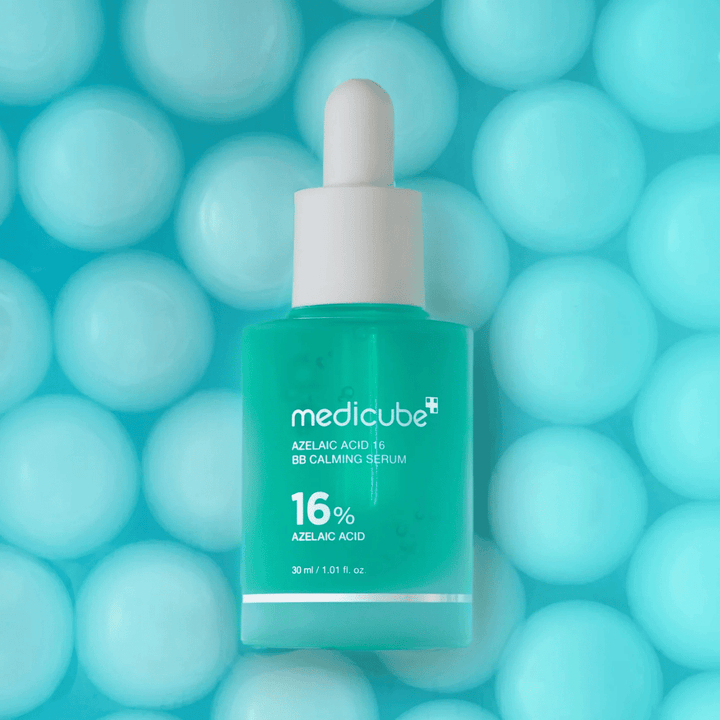 Imagem de campanha de Medicube Azelaic Acid 16 BB Calming Serum contra um fundo turquesa com esferas suaves que simbolizam hidratação, efeito calmante e textura uniforme da pele.