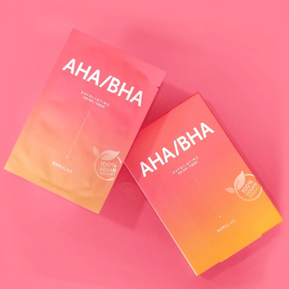 Dois produtos de BARULAB, um em um saco e outro em uma caixa, ambos marcados com "AHA/BHA" e "Exfoliating" contra um fundo rosa. Os produtos são marcados como "Produto 100% Vegano".