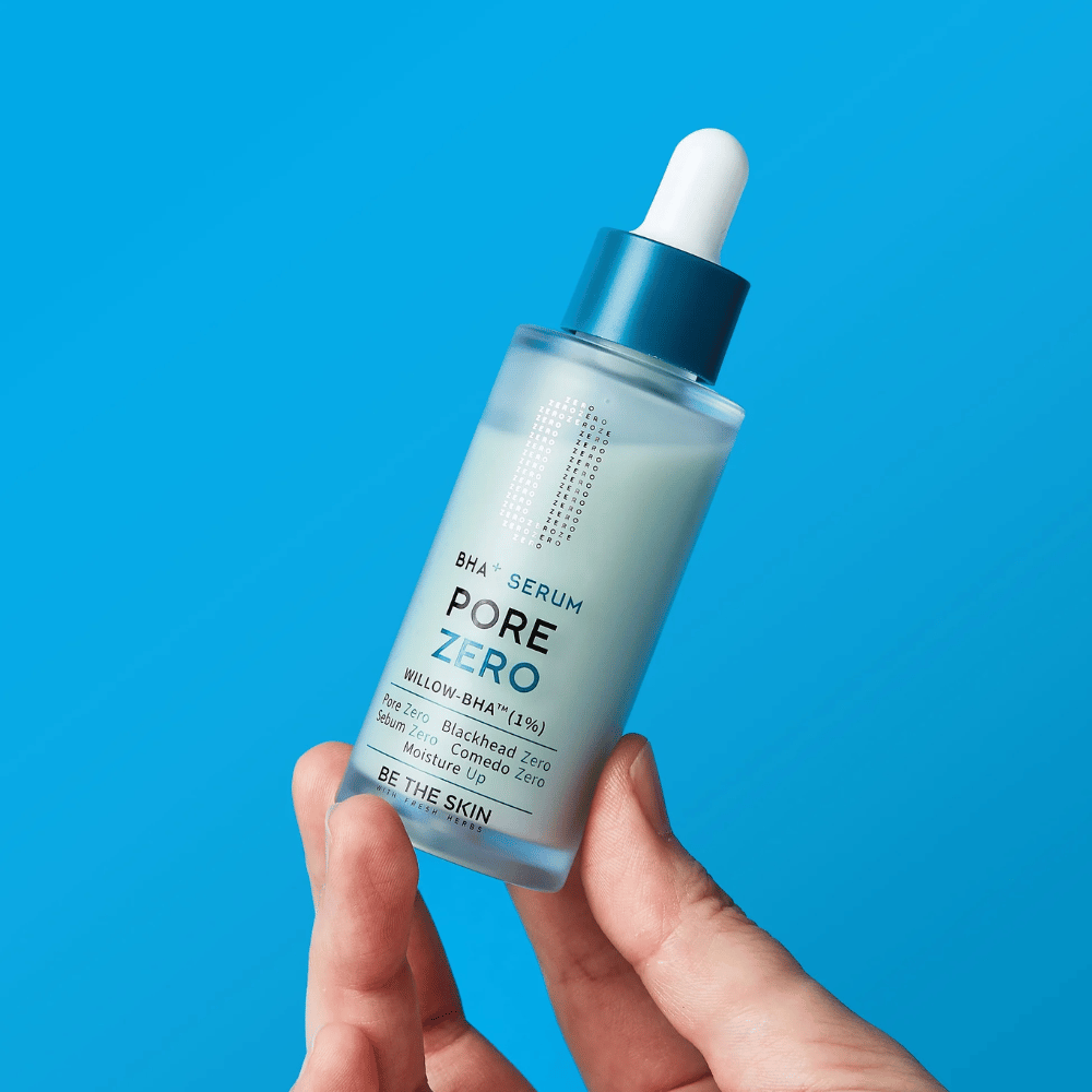 Be The Skin BHA+ Pore Zero Serum segurado na mão sobre fundo azul