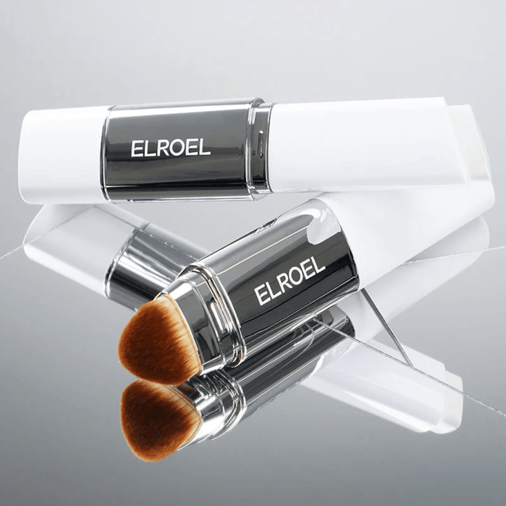 ELROEL Blanc Cover Cream Stick com pincel integrado colocado em superfície espelhada para mostrar cerdas macias e aplicação uniforme.
