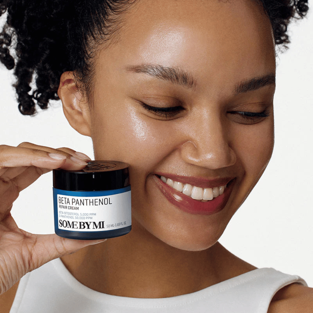 Modelo com pele luminosa segurando SOME BY MI Beta Panthenol Repair Cream – creme facial coreano que fortalece a barreira da pele e hidrata.