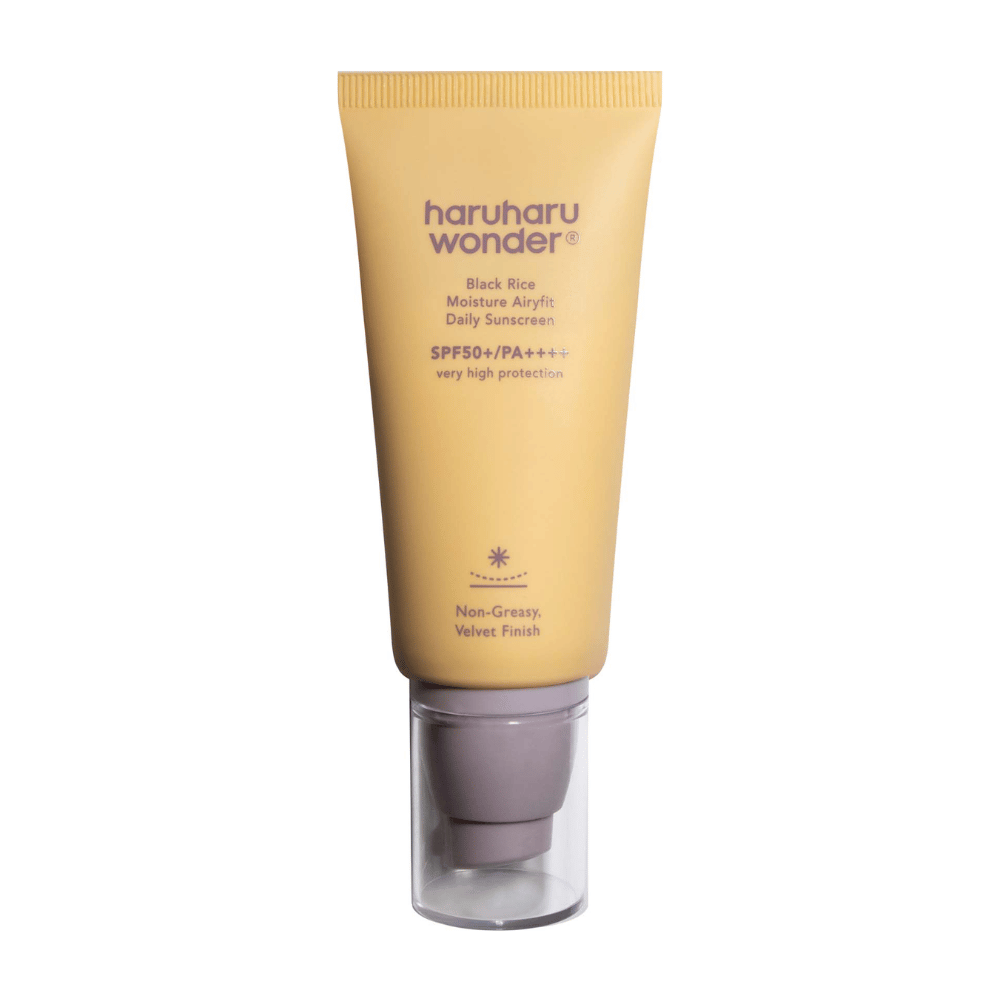 Um tubo amarelo com Haruharu Wonder Black Rice Moisture Airyfit Daily Sunscreen SPF 50+ PA++++. O tubo tem uma tampa transparente e texto que descreve o alto nível de proteção do protetor solar e seu acabamento não oleoso e aveludado.