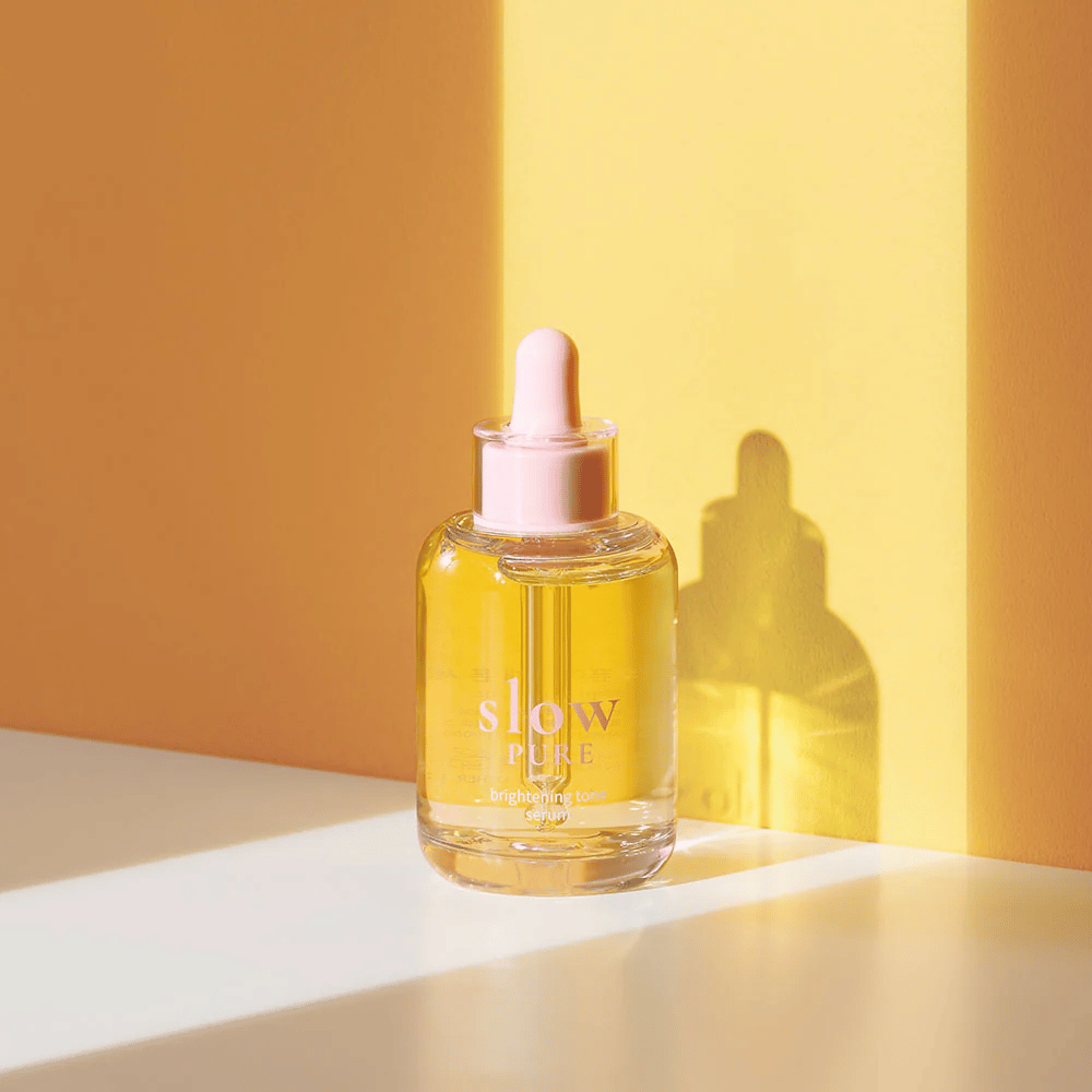 Slow Pure Brightening Tone Serum em luz amarela ensolarada, simboliza brilho e energia para a pele.