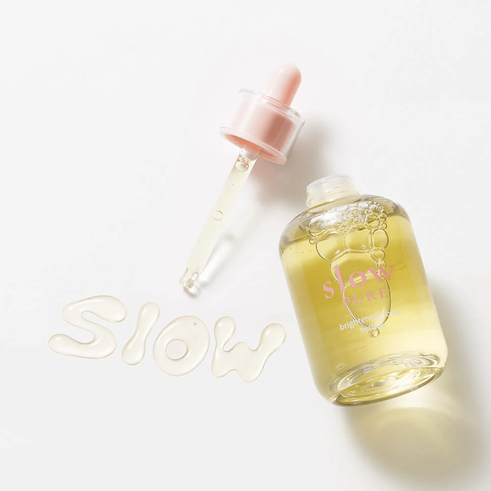 Slow Pure Brightening Tone Serum com pipeta aberta, texto escrito no sérum na superfície: "Slow".