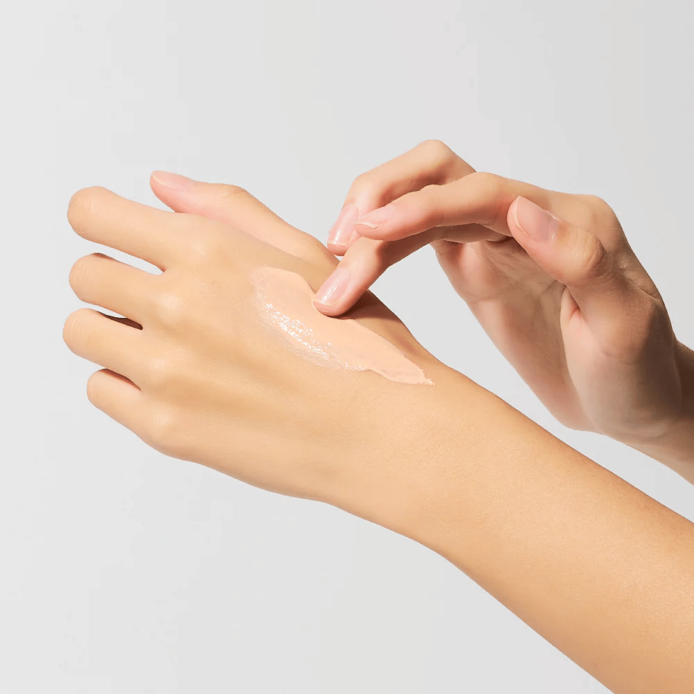 Aplicação de Dr.Melaxin Cemenrete Eye Cream na mão, creme para os olhos cremoso com cálcio e elastina que é rapidamente absorvido e proporciona hidratação intensa.