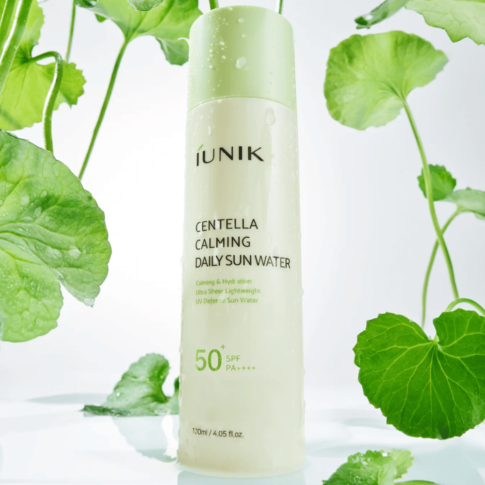 2. iUNIK Centella Calming Daily Sun Water SPF50+ PA++++ – protetor solar hidratante com centella asiatica rodeado por folhas verdes e gotas de água