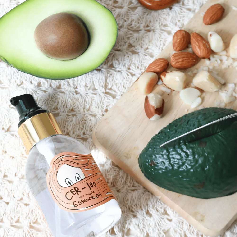 Elizavecca CER-100 Hair Muscle Essence Oil ingredientes – close-up com abacate e óleos vegetais que mostra um óleo capilar rico em nutrientes que ajuda a suavizar e nutrir o cabelo.