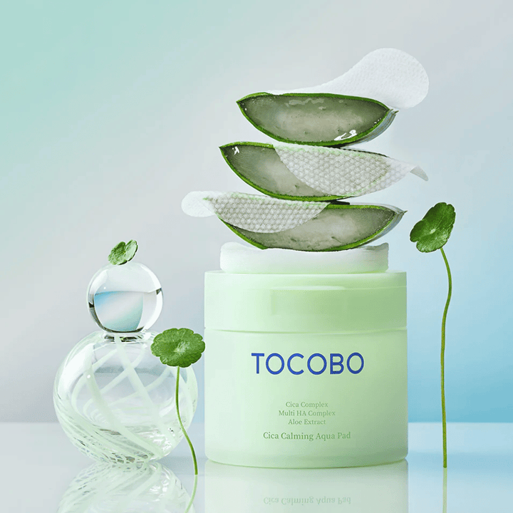TOCOBO Cica Calming Aqua Pad é apresentado juntamente com discos tónicos, aloé vera e centella asiatica. A imagem destaca os ingredientes hidratantes e calmantes do produto.