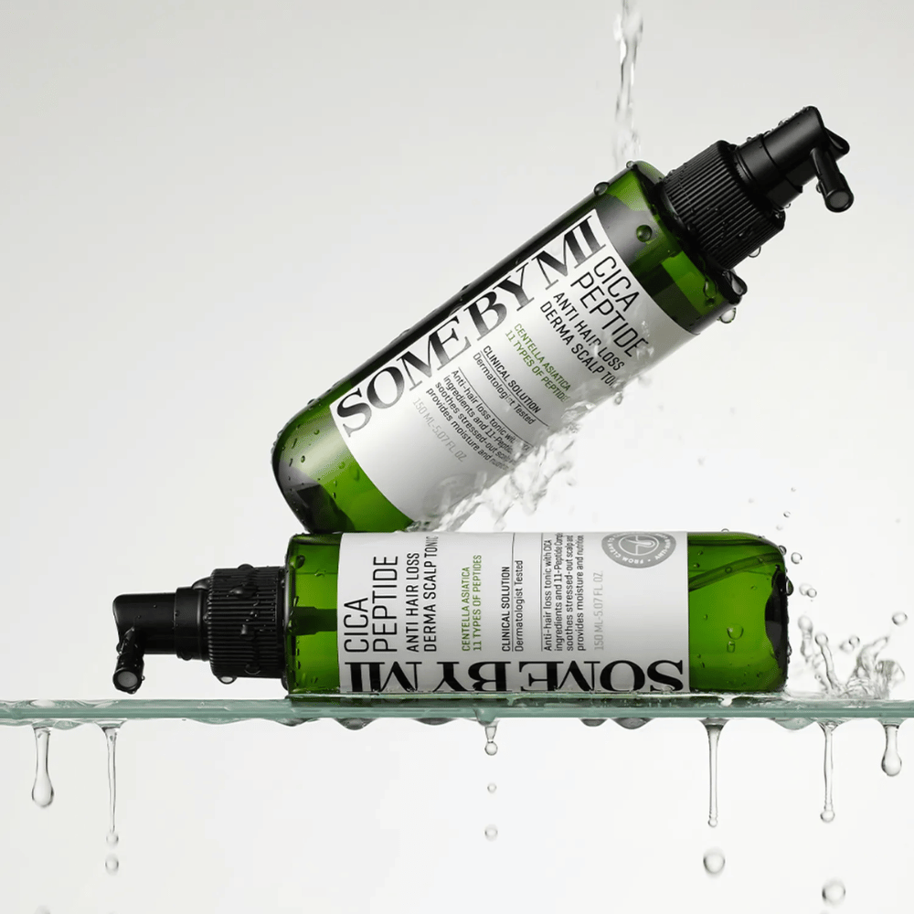 Duas garrafas SOME BY MI Cica Peptide Anti Hair Loss Derma Scalp Tonic estão dentro e acima da água com gotas salpicando, garrafas verdes com bico de spray preto e rótulo branco.