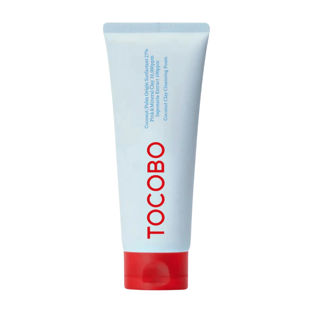 O tubo de TOCOBO Coconut Clay Cleansing Foam é visível. O tubo é azul claro com uma tampa vermelha e o texto "TOCOBO" em letras grandes na frente. O produto é descrito como uma espuma de limpeza de argila de coco e contém ingredientes naturais.
