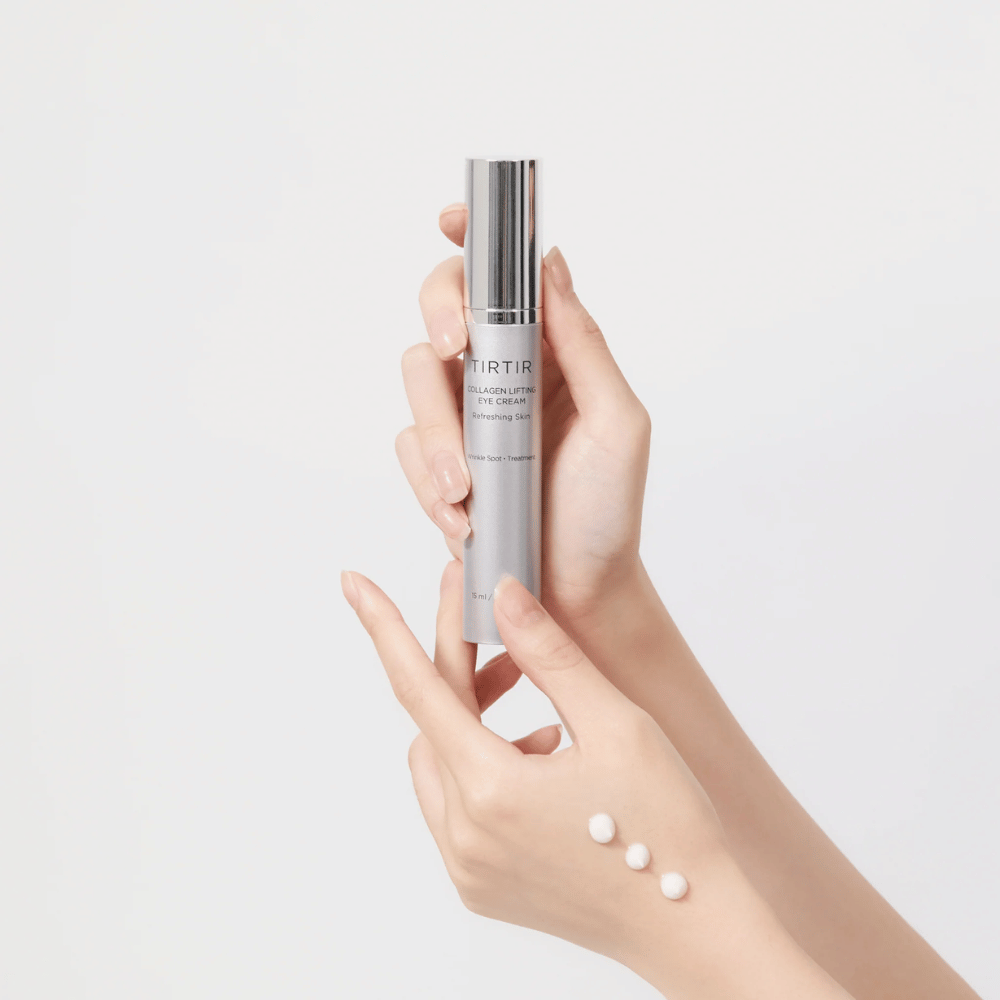 Mãos segurando um tubo com TIRTIR Collagen Lifting Eye Cream, com o produto espremido no dorso da mão.