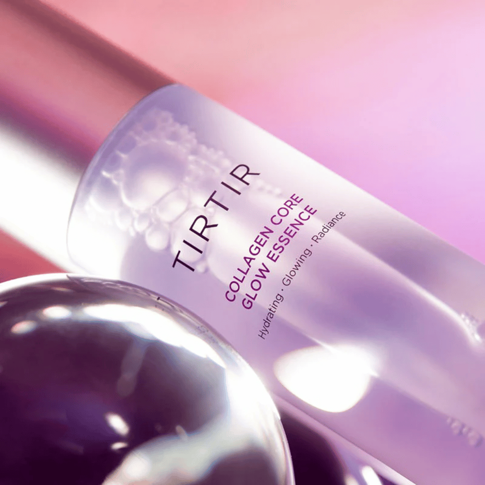 Close-up de TIRTIR Collagen Core Glow Essence – essência iluminadora em uma garrafa roxa elegante com foco em hidratação e brilho natural da pele.