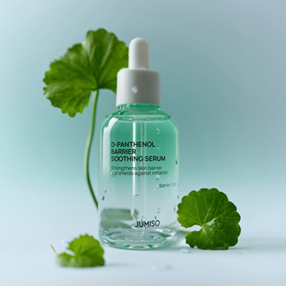 Jumiso D-Panthenol Barrier Soothing Serum em frasco de vidro transparente com conta-gotas, colocado com folhas verdes ao fundo.