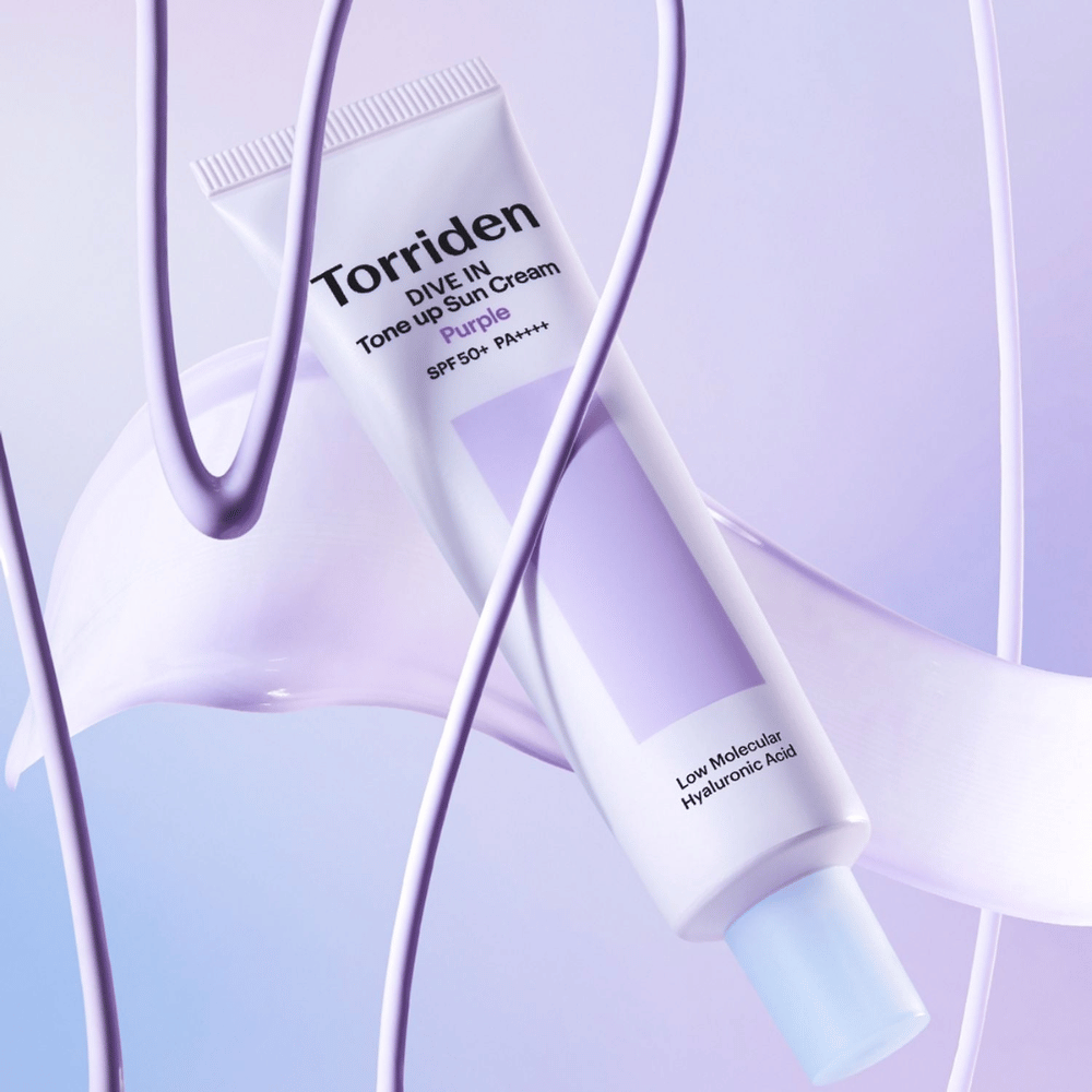 Torriden DIVE IN Tone Up Sun Cream Purple SPF50+ PA++++ apresentada num cenário criativo de produto com detalhes lilases que destacam a fórmula hidratante.