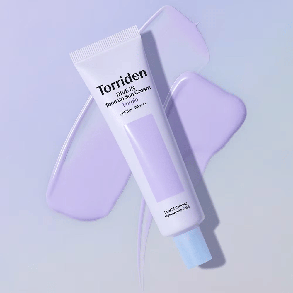 Torriden DIVE IN Tone Up Sun Cream Purple colocada sobre creme lilás espalhado que realça o efeito uniformizador do tom e iluminador.