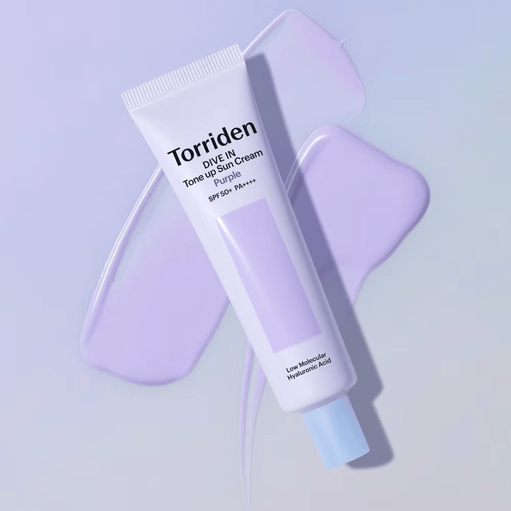 Torriden DIVE IN Tone Up Sun Cream Purple colocada sobre creme lilás espalhado que realça o efeito uniformizador do tom e iluminador.