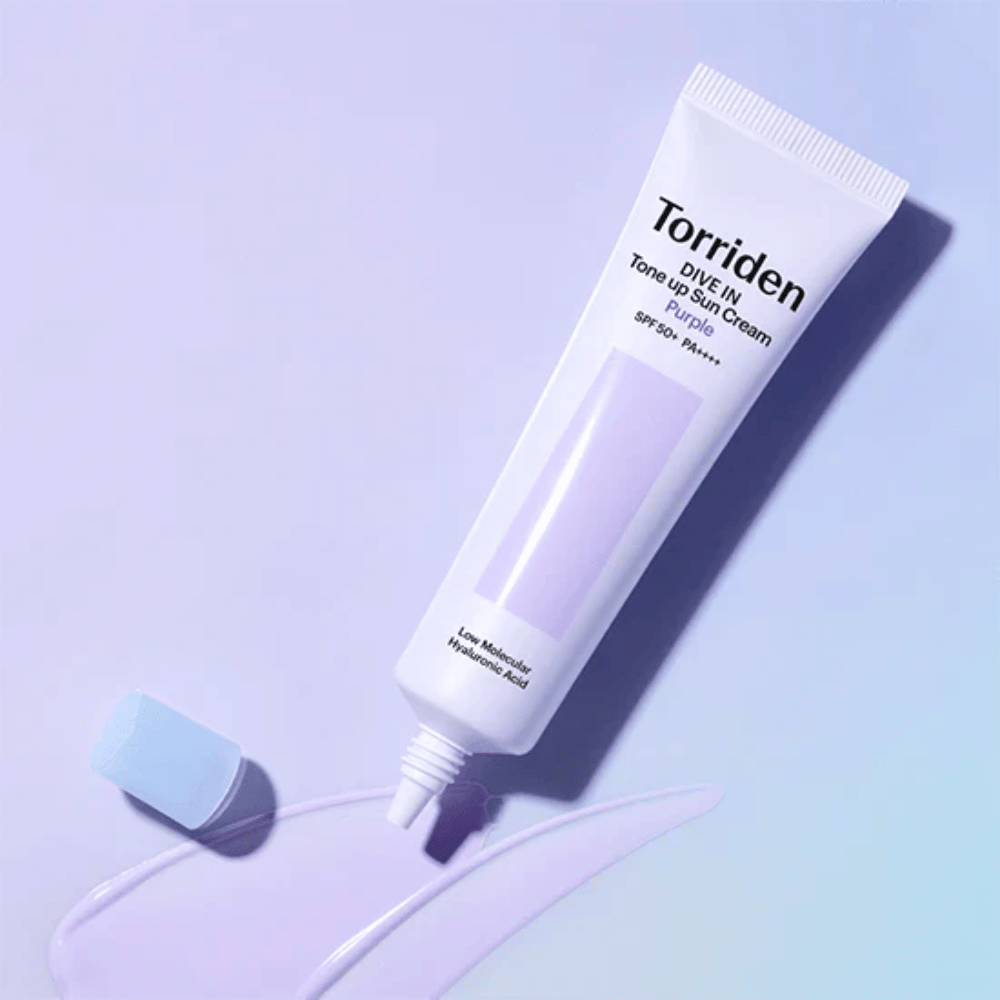 Tubo aberto de Torriden DIVE IN Tone Up Sun Cream Purple com textura de protetor solar de tom lilás que mostra a fórmula corretora de cor do produto.