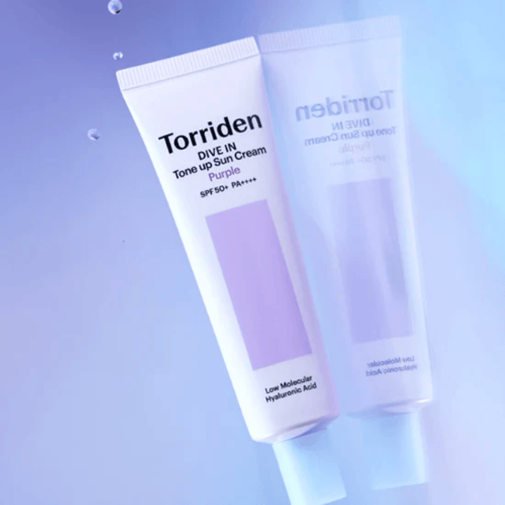 Torriden DIVE IN Tone Up Sun Cream Purple SPF50+ PA++++ fotografada sobre um fundo lilás suave que destaca o design refletor de luz do produto.