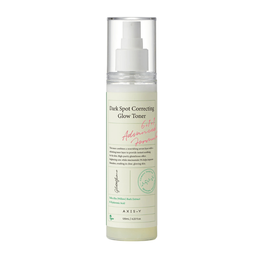 Uma imagem de uma garrafa do produto "AXIS-Y Dark Spot Correcting Glow Toner". A garrafa é transparente com um rótulo branco e texto em preto e verde. O produto é um toner em forma de spray, e a garrafa contém 125 ml (4,23 fl. oz). O rótulo menciona ingredientes-chave como Extrato de Casca de Salgueiro e Ácido Hialurônico.