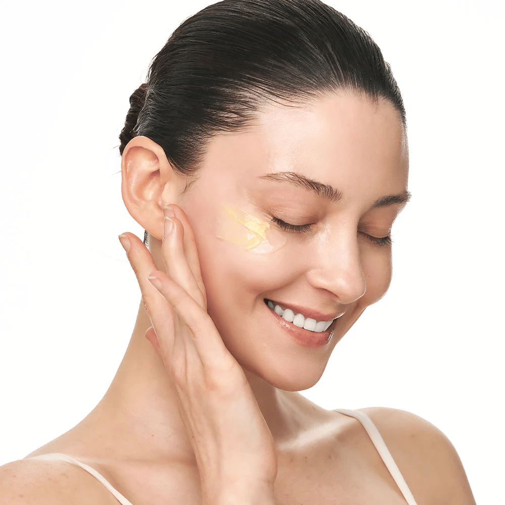Pessoa massageia Sungboon Editor Deep Collagen Retinol Capsule Cream na bochecha. O produto proporciona brilho, firmeza e hidratação duradoura.