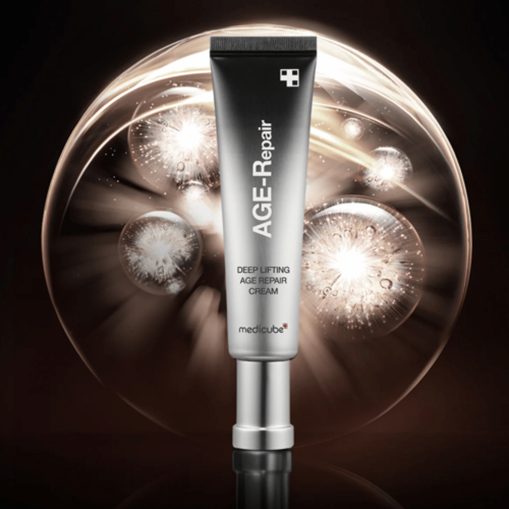 Medicube Deep Lifting Age Repair Cream em tubo prateado contra fundo com efeitos de luz, simbolizando anti-envelhecimento e renovação da pele.