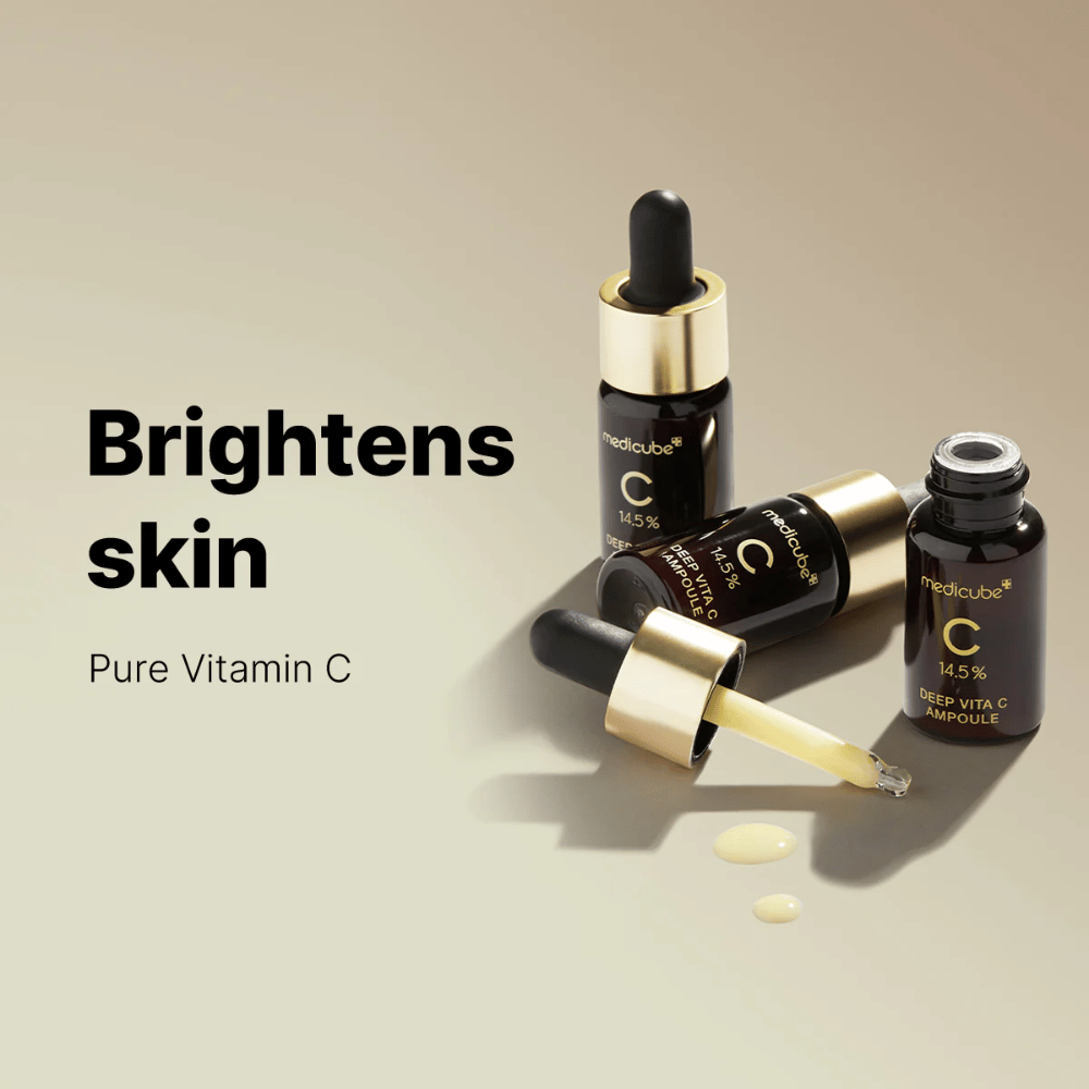 Medicube Deep Vita C Ampoule com 14,5 % de vitamina C, exibido em frascos elegantes com conta-gotas dourados. O produto é projetado para iluminar o tom da pele e proporcionar uma tez radiante. O texto "Brightens skin" e "Pure Vitamin C" reforça a mensagem.