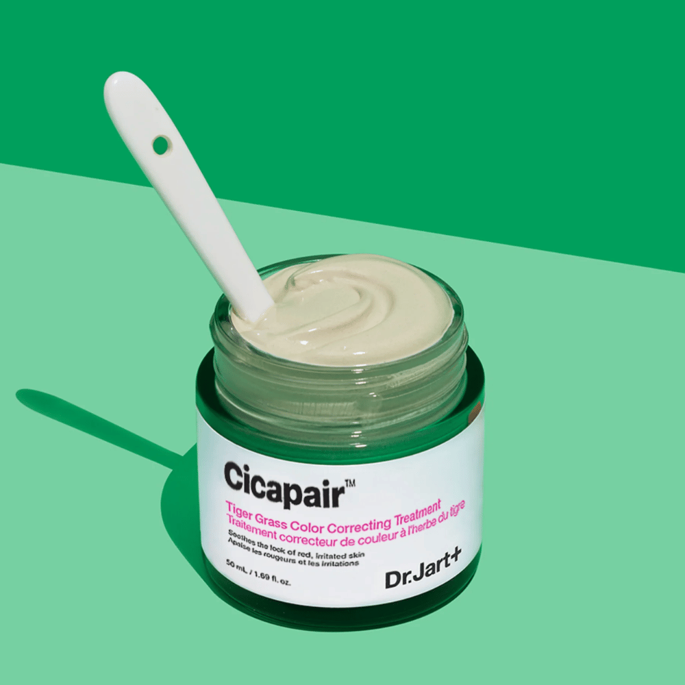 Um frasco Cicapair Tiger Grass Color Correcting Treatment 50ml de Dr Jart+ em fundo verde.
