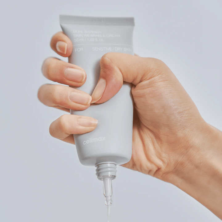 Mão aplicando Celimax Dual Barrier Skin Wearable Cream, creme facial que fortalece a barreira para pele sensível e seca que proporciona hidratação duradoura e protege a barreira da pele.