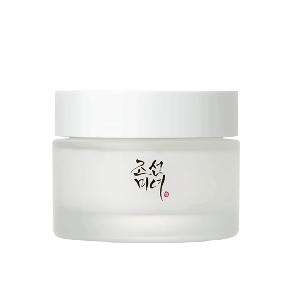A imagem mostra um frasco "Beauty of Joseon Dynasty Cream". A embalagem é de vidro fosco com uma tampa branca simples, elegantemente decorada com caligrafia tradicional coreana em preto. O produto destina-se a oferecer cuidados nutritivos para a pele, inspirados em antigas rotinas de beleza coreanas.
