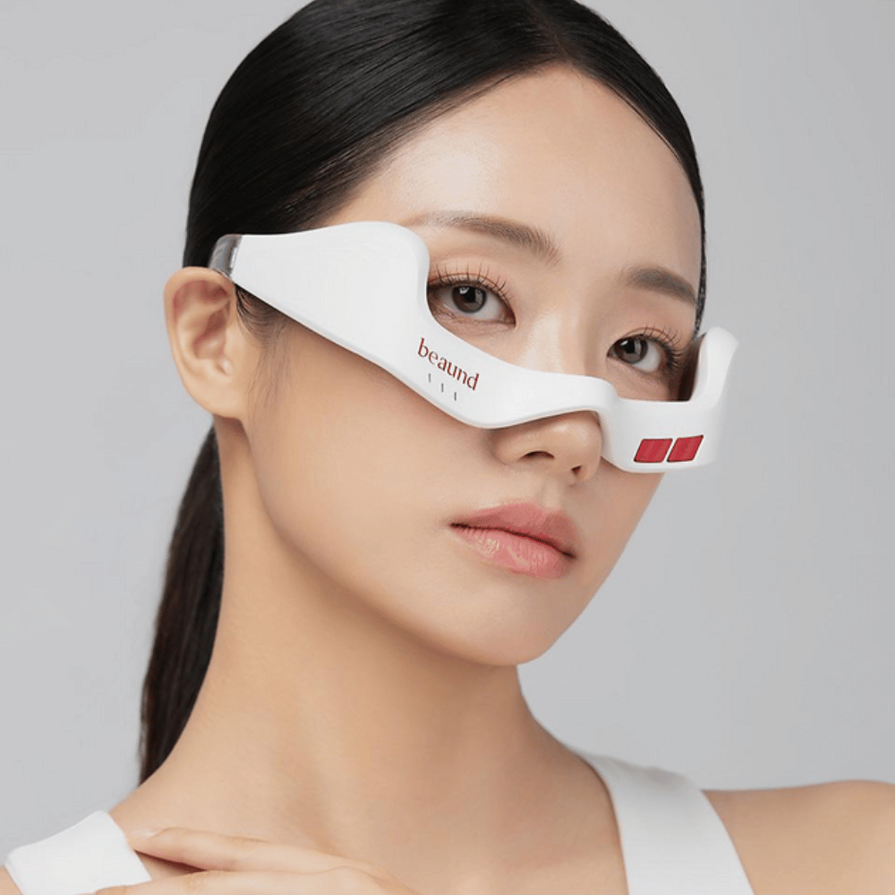 Grande plano de um modelo a usar Beaund Eye Rejuv para destacar o ajuste ergonómico e o design elegante à volta da zona dos olhos.