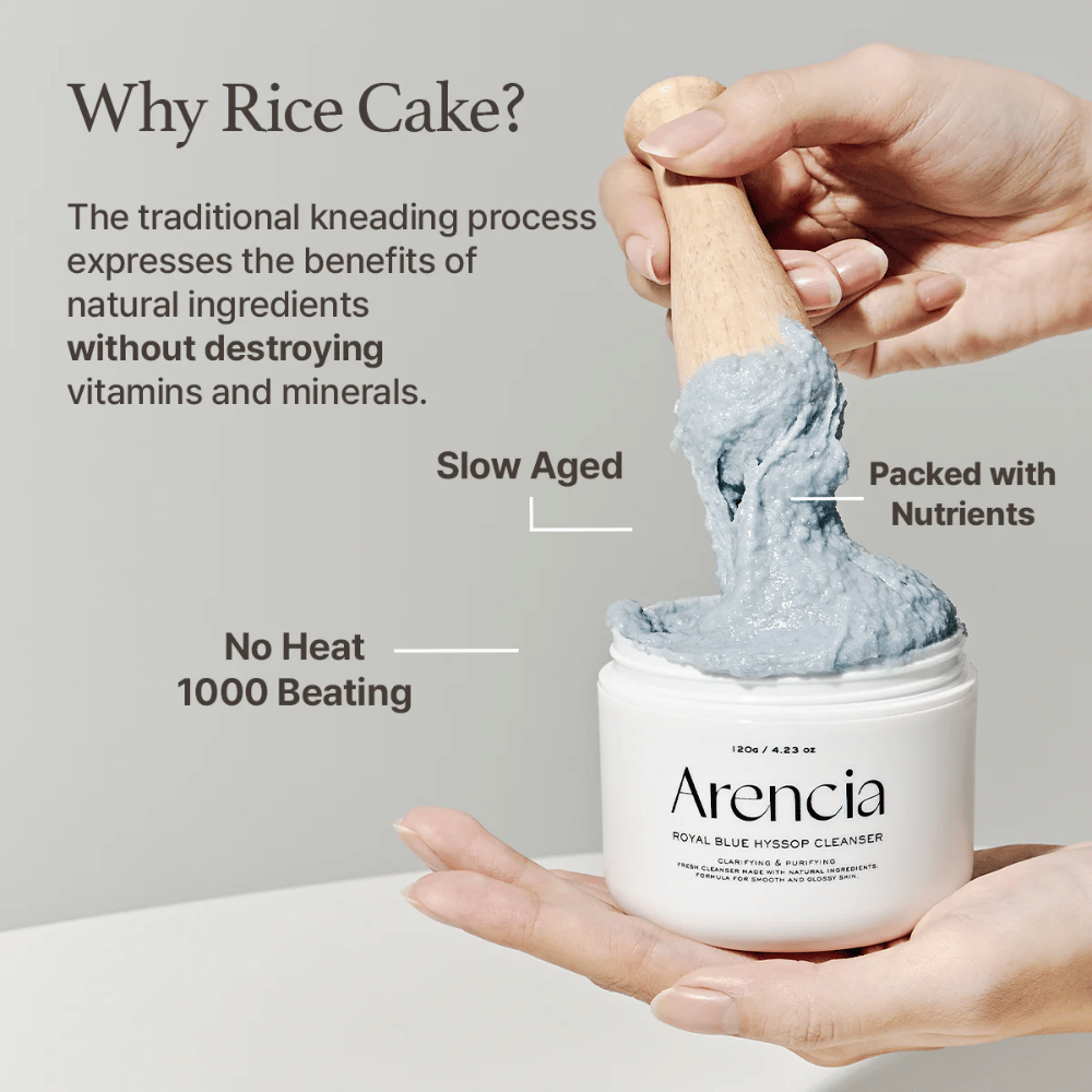 Mão segurando o frasco de limpeza "Arencia Royal Blue Hyssop Cleanser" com uma colher de pau levantando a pasta de limpeza azul, semelhante a mochi. O texto na imagem descreve os benefícios do processo de massa de arroz, como "Sem Calor", "1000 Batidas", "Envelhecido Lentamente" e "Repleto de Nutrientes".