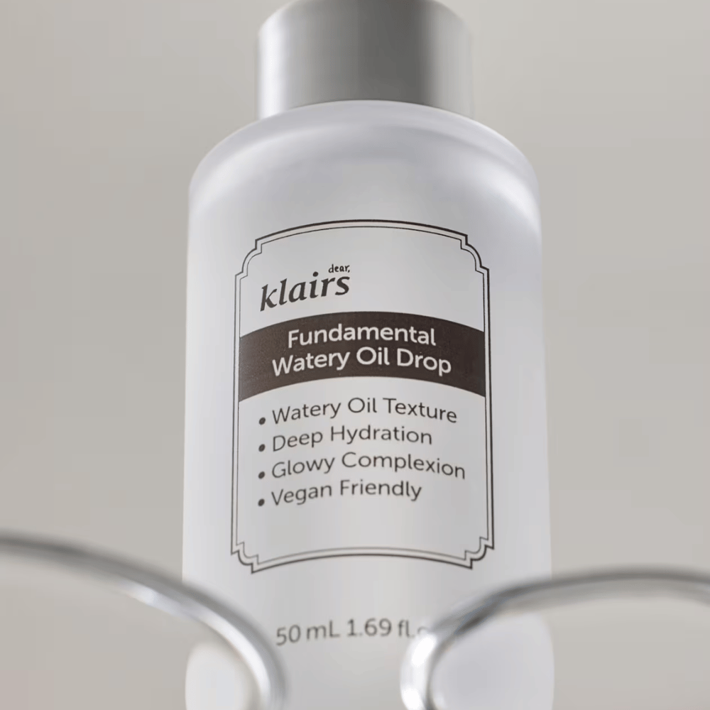 Frasco com Klairs Fundamental Watery Oil Drop, 50 ml, colocado em um suporte transparente, com rótulo claro destacando as propriedades hidratantes e veganas do produto.