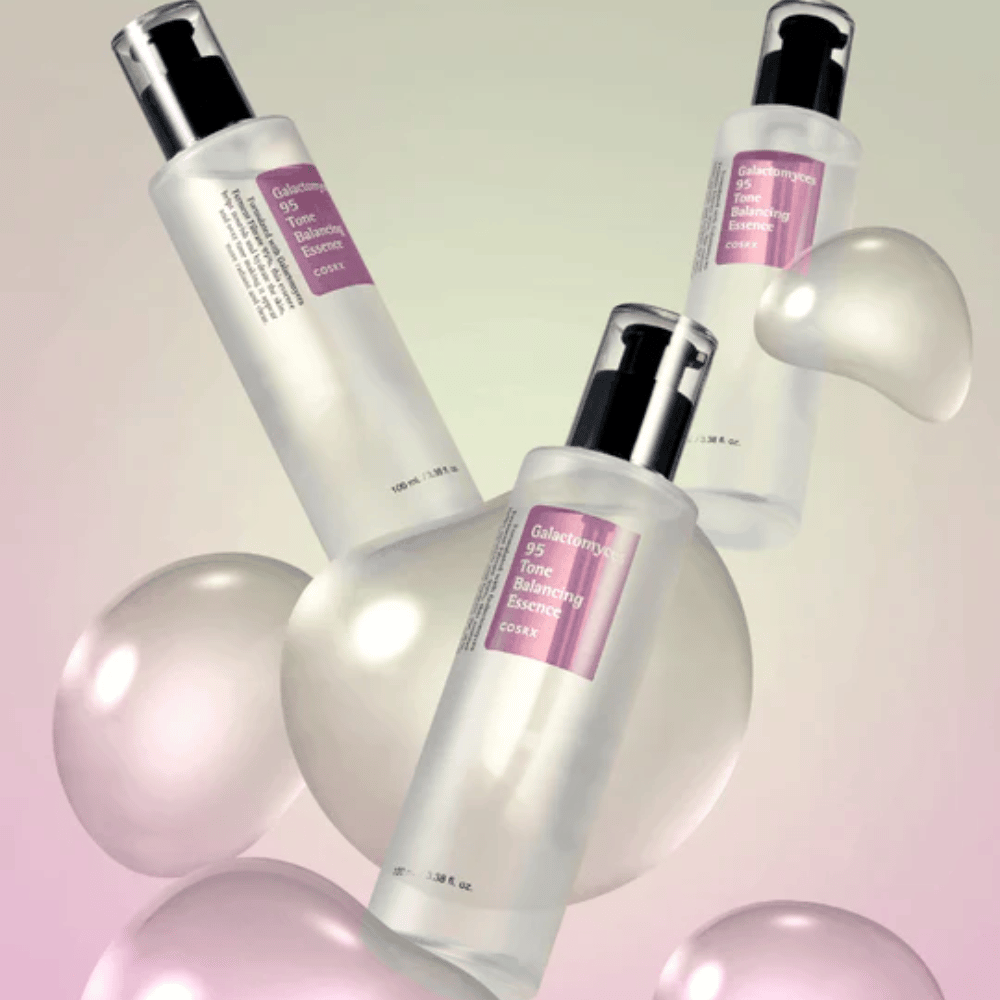 Três frascos de COSRX Galactomyces 95 Tone Balancing Essence cercados por bolhas claras. Essência que melhora a pele, uniformiza o tom e proporciona brilho natural.